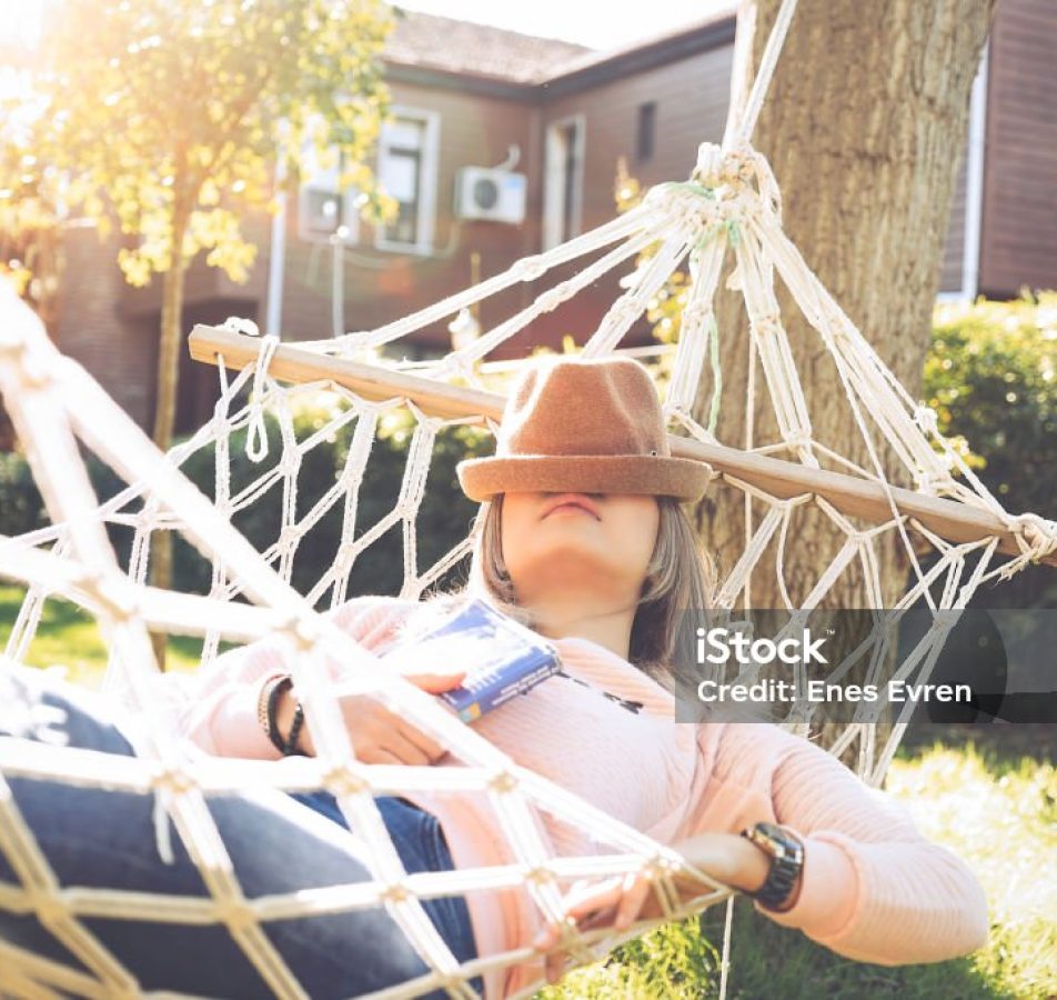 Young woman lying down and sleeping on a hammock